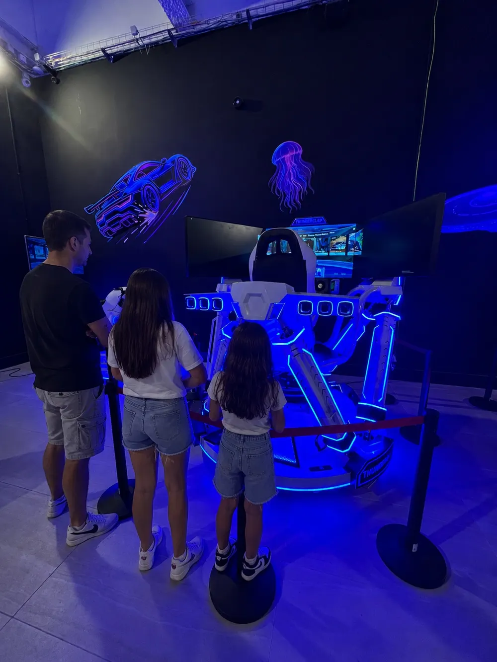 A parent and kids at a VR simulator at the Space Run VR venue