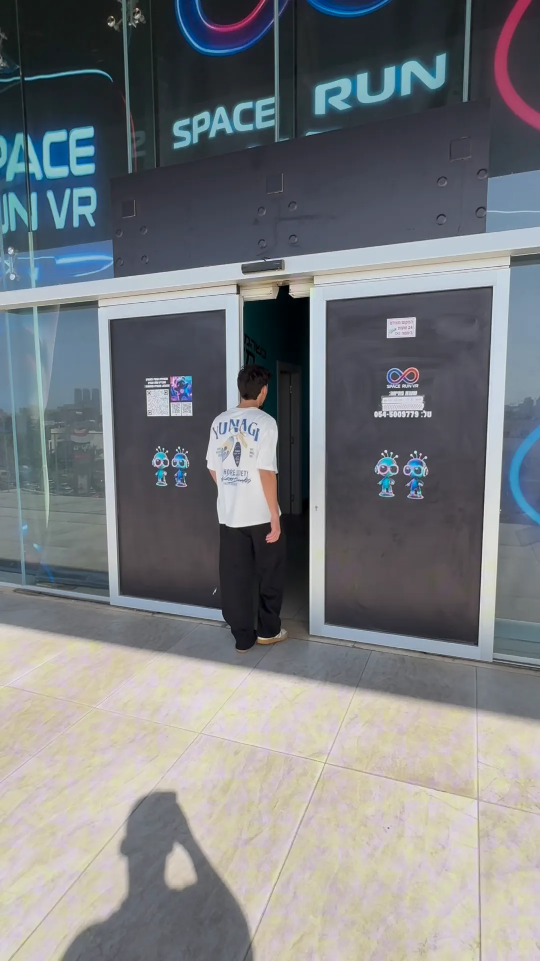 The venue's entrance doors with Space Run VR signage, a visitor walking in (seen from behind)
