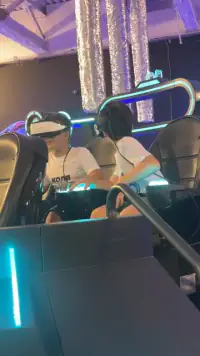 שני בנים צוחקים בכיסאות ה־UFO עם משקפי VR