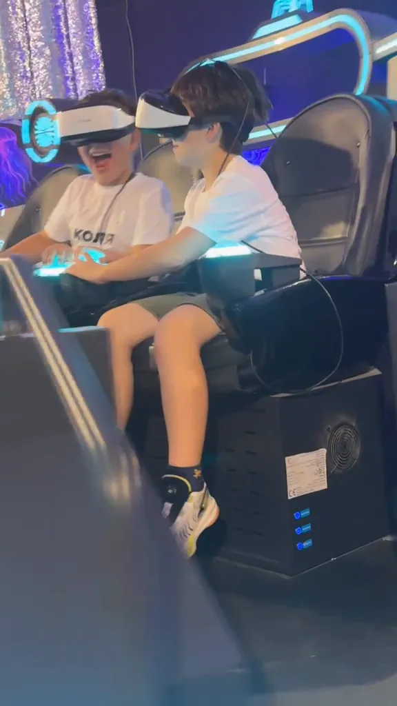 שני בנים צוחקים בכיסאות ה־UFO עם משקפי VR